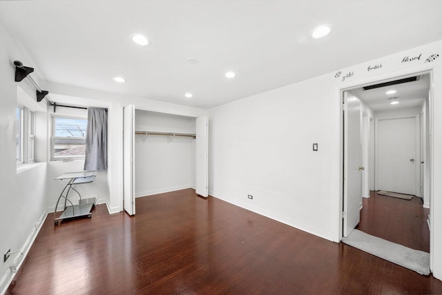 unfurnished bedroom with dark hardwood / wood-style flooring and a closet