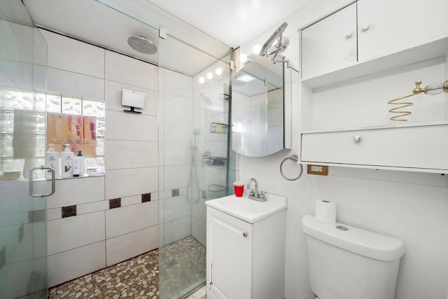 bathroom featuring sink, a shower with shower door, and toilet