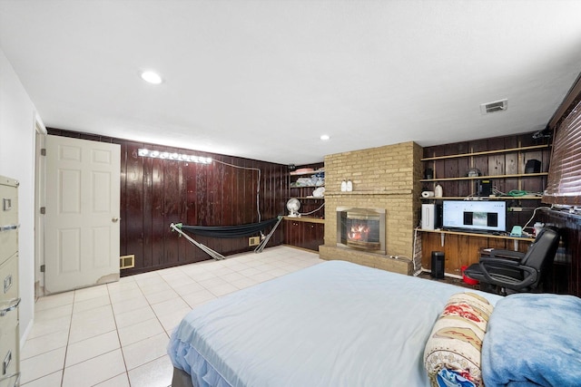 tiled bedroom featuring a fireplace and wooden walls