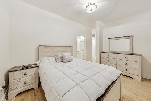 bedroom featuring ensuite bath and light hardwood / wood-style flooring