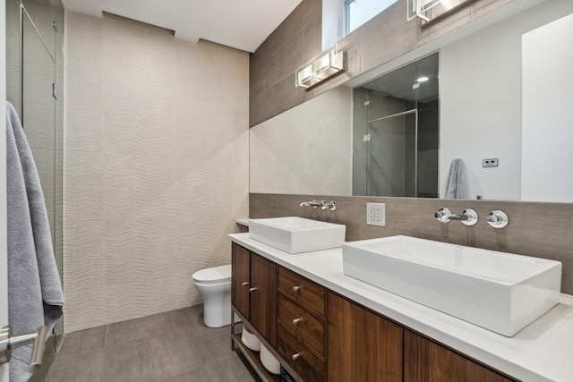 bathroom featuring vanity, tile walls, walk in shower, and toilet