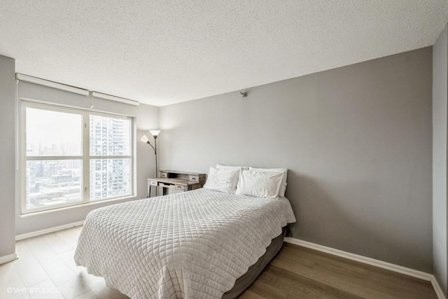 bedroom featuring a textured ceiling and light wood-type flooring