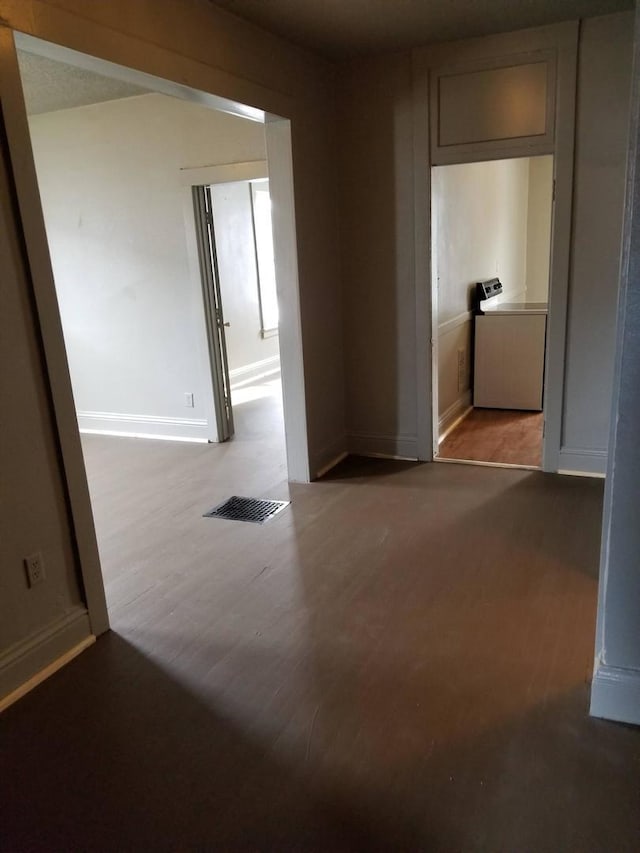 unfurnished room featuring washer / dryer and hardwood / wood-style floors