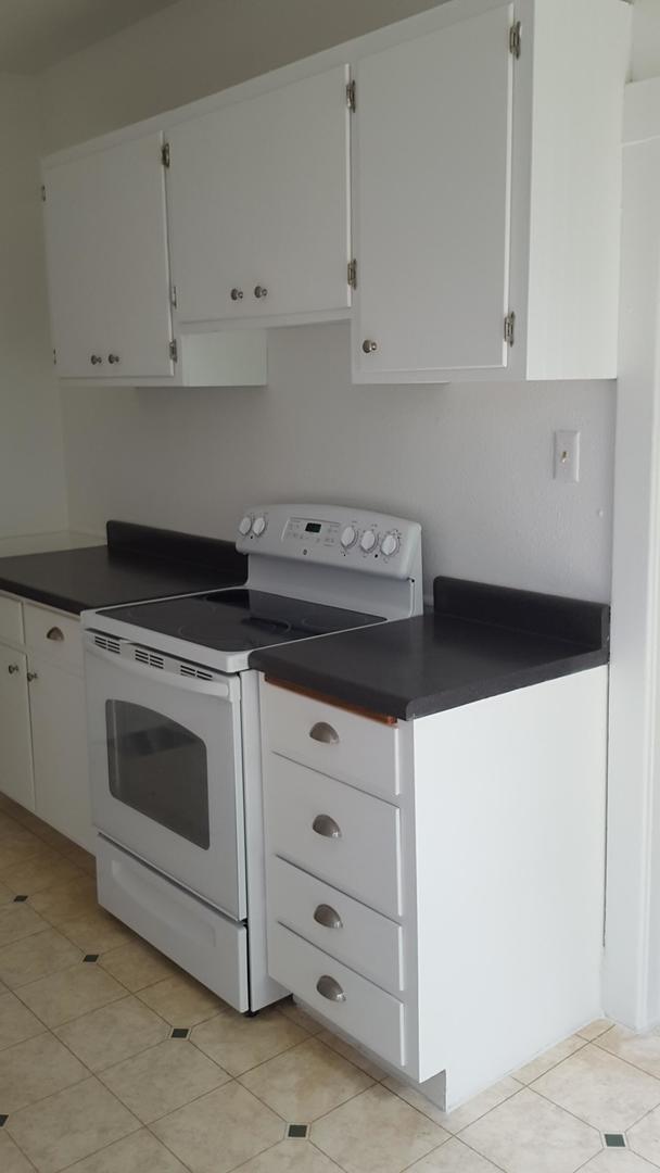 kitchen featuring white cabinetry, white electric range, and light tile patterned flooring