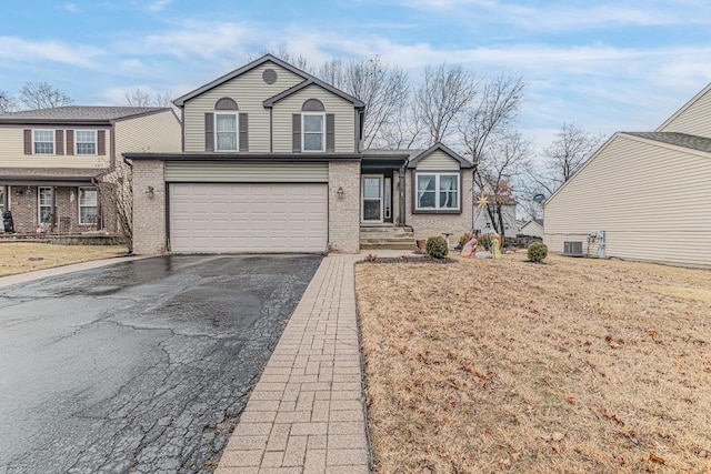 front facade with cooling unit, a garage, and a front lawn