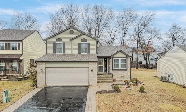 view of front of house with central AC unit, a garage, and a front yard