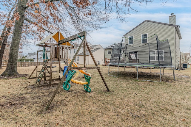 view of playground with cooling unit, a trampoline, and a lawn