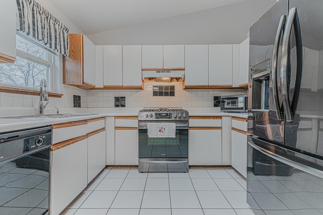 kitchen with tasteful backsplash, light tile patterned flooring, appliances with stainless steel finishes, and white cabinets