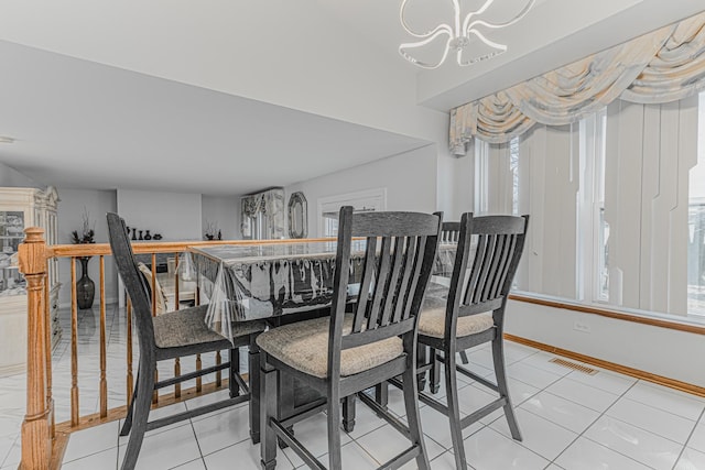 dining space featuring light tile patterned floors, a chandelier, and a healthy amount of sunlight