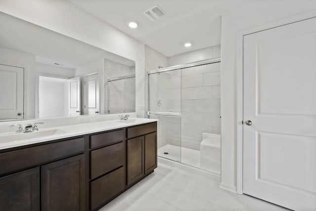 bathroom featuring vanity, a shower with shower door, and tile patterned floors