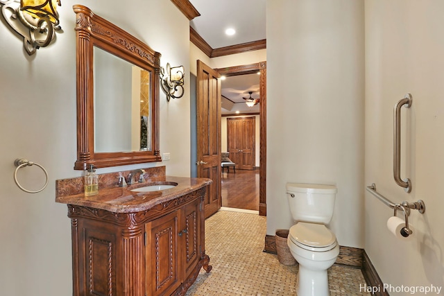 bathroom with crown molding, ceiling fan, vanity, and toilet