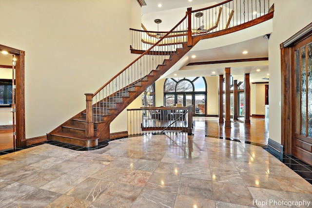 foyer with a towering ceiling and decorative columns