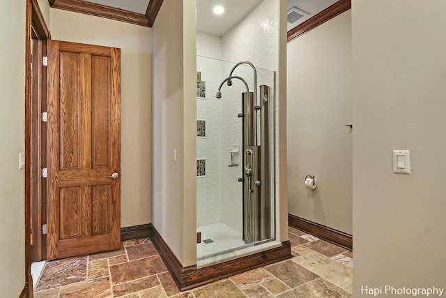 bathroom with crown molding and an enclosed shower