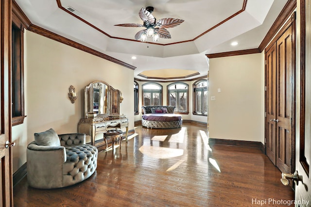 bedroom featuring crown molding, dark wood-type flooring, and a tray ceiling