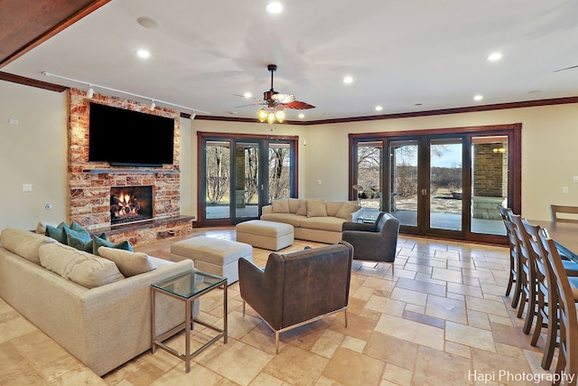 living room with french doors, a large fireplace, crown molding, and ceiling fan