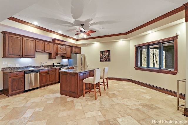 kitchen with stainless steel appliances, a center island, ornamental molding, a kitchen bar, and dark stone counters