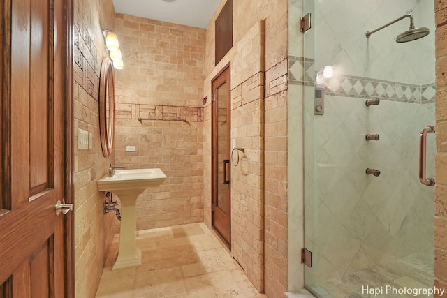 bathroom with a stall shower and stone tile flooring