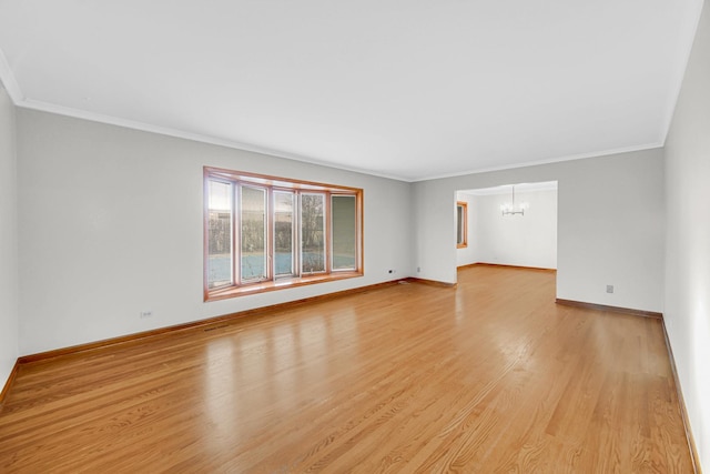 spare room with a notable chandelier, light hardwood / wood-style flooring, and ornamental molding