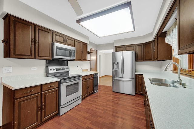 kitchen featuring appliances with stainless steel finishes, sink, dark hardwood / wood-style flooring, and dark brown cabinets