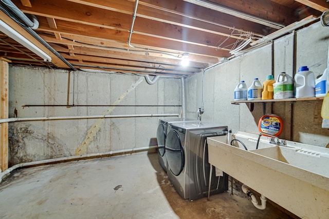 clothes washing area with washer and dryer and sink