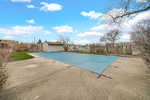 view of swimming pool with a patio area and a shed