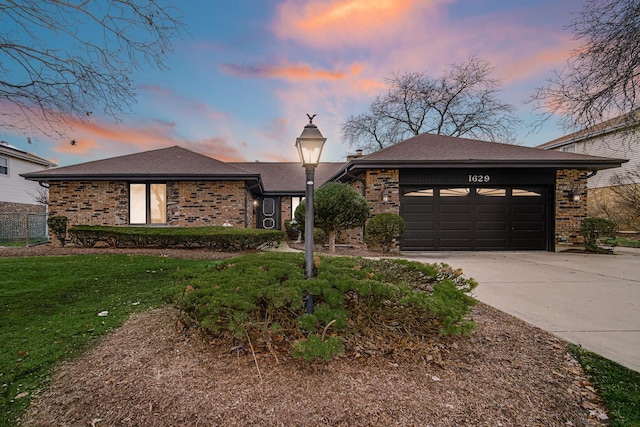 view of front of property featuring a garage and a yard