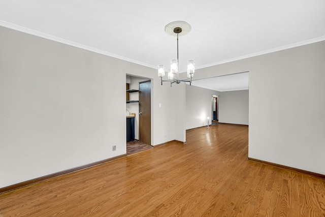 unfurnished dining area with crown molding, hardwood / wood-style floors, and a notable chandelier