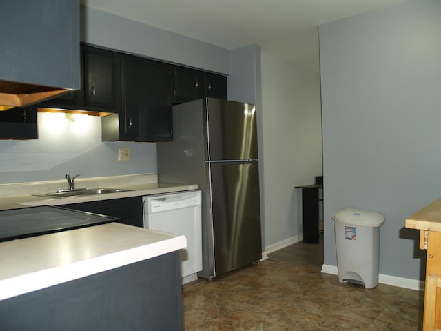 kitchen featuring dishwasher, sink, and stainless steel refrigerator