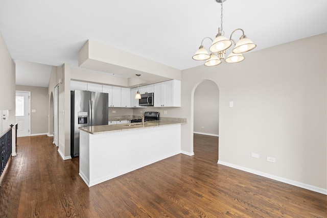 kitchen featuring white cabinetry, stainless steel appliances, dark hardwood / wood-style floors, and kitchen peninsula