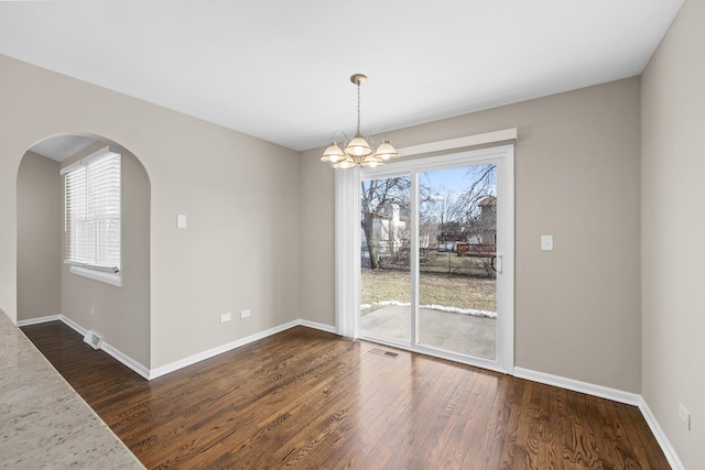 unfurnished dining area with dark wood-type flooring and a chandelier