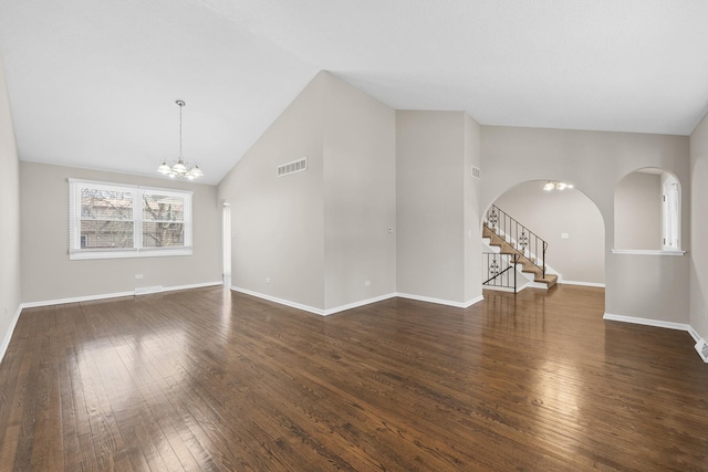 unfurnished living room with lofted ceiling, dark hardwood / wood-style floors, and a chandelier