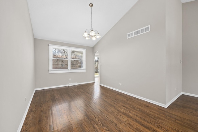 spare room featuring dark hardwood / wood-style floors, high vaulted ceiling, and a notable chandelier