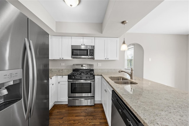 kitchen featuring sink, white cabinetry, hanging light fixtures, stainless steel appliances, and light stone countertops