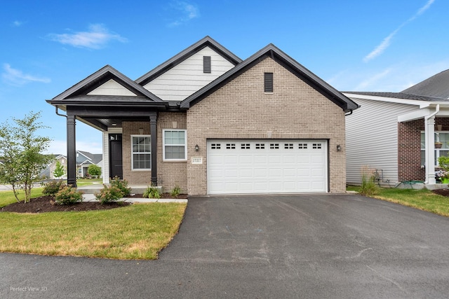 view of front of property with an attached garage, aphalt driveway, and brick siding