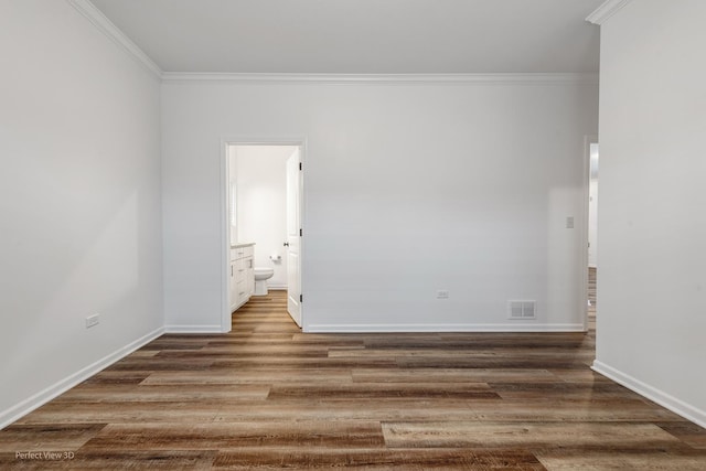 unfurnished room with ornamental molding, visible vents, baseboards, and wood finished floors