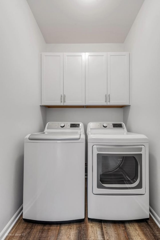 laundry area with cabinet space, washer and clothes dryer, baseboards, and wood finished floors