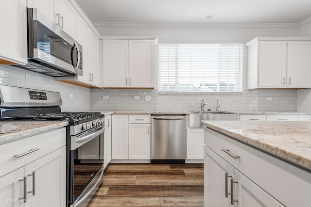 kitchen featuring ornamental molding, appliances with stainless steel finishes, dark wood-style floors, and white cabinetry