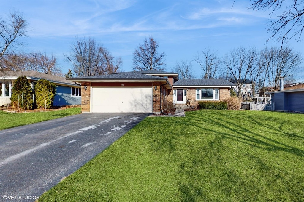 ranch-style house featuring a garage and a front lawn