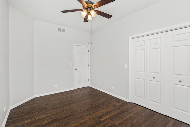 unfurnished bedroom featuring ceiling fan, dark hardwood / wood-style flooring, and a closet