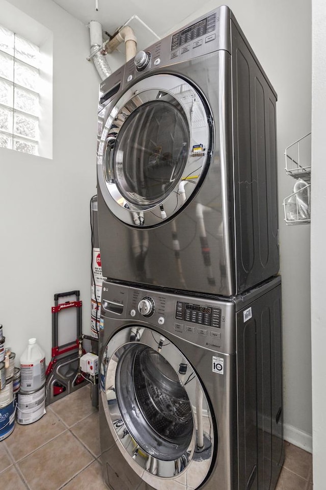 laundry room with stacked washer / drying machine and tile patterned floors