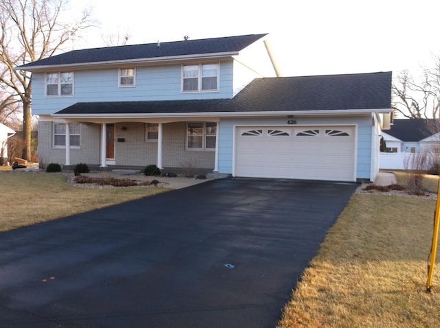 front of property with a porch, a garage, and a front yard