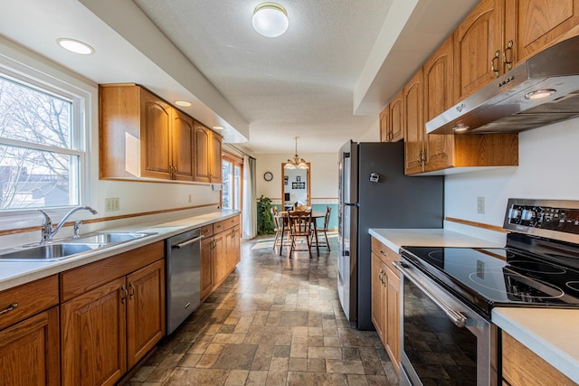 kitchen featuring sink, a wealth of natural light, hanging light fixtures, and appliances with stainless steel finishes