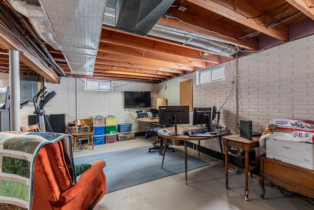 basement with brick wall and plenty of natural light