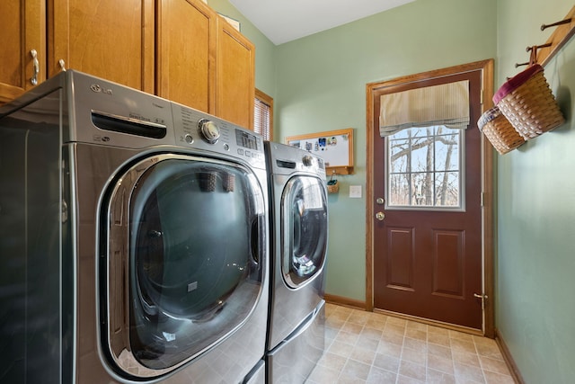 laundry room featuring washer and dryer and cabinets