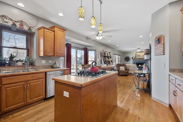 kitchen with stainless steel appliances, a center island, sink, and light hardwood / wood-style floors