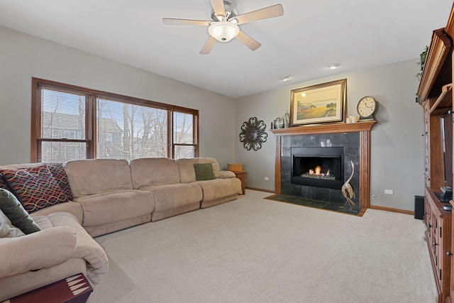 living room with ceiling fan, light colored carpet, and a fireplace