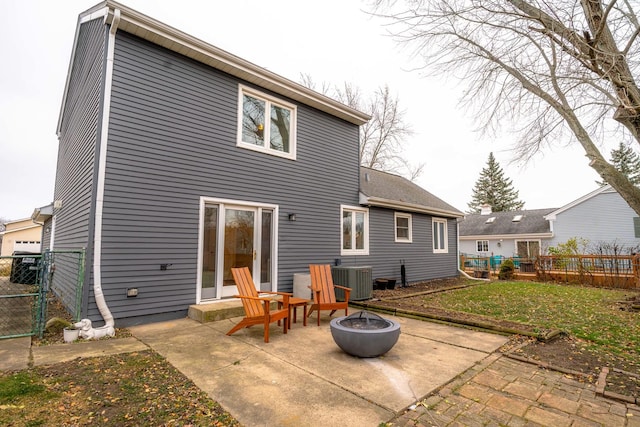 back of house with central AC, a lawn, a patio, and an outdoor fire pit