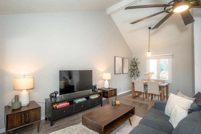 living room featuring ceiling fan, high vaulted ceiling, beamed ceiling, and light wood-type flooring