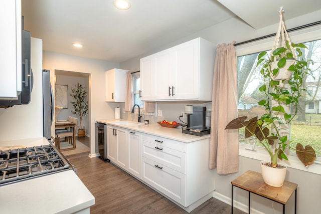 kitchen with wine cooler, dark hardwood / wood-style floors, sink, and white cabinets