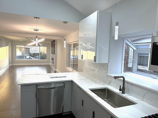 kitchen featuring light stone counters, sink, pendant lighting, and gray cabinetry